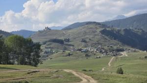 a green hill with a castle on top of it at Sky Tusheti in Omalo +12 photos