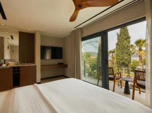 a bedroom with a large bed and a large window at Selimiye Sardunya Hotel & Restaurant in Marmaris