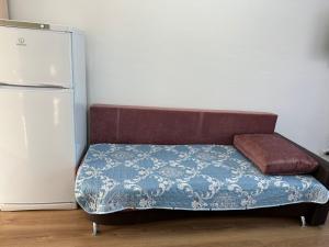 a bed in a room next to a refrigerator at Promenade Burabay 2 in Borovoye