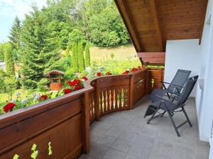 a porch with two chairs and flowers on it at Privatzimmer am Weinbrunnen in Vorchdorf +22 photos