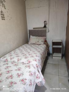 a bedroom with a bed with a floral bedspread at Anexo Golden in Cochabamba