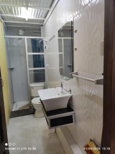 a white bathroom with a sink and a toilet at Anexo Golden in Cochabamba