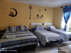 a bedroom with two beds and a bike on the wall at Anexo Golden in Cochabamba