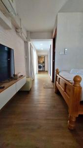 a bedroom with a bed and a flat screen tv at Flow Garden Residence in Chiang Mai