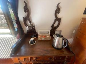 a table with a tea kettle and a clock on it at Torre Della Chiocciola in Monteriggioni