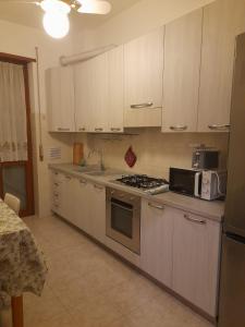 a kitchen with a stove and a microwave at Casa Pirandello 3 min Metro in Sesto San Giovanni