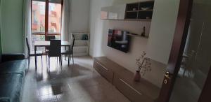 a living room with a table and a couch at Casa Pirandello 3 min Metro in Sesto San Giovanni