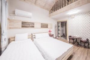 済州市にあるRed Windmill Pensionのベッドルーム1室(ベッド2台、テーブル、椅子付) +37枚の写真