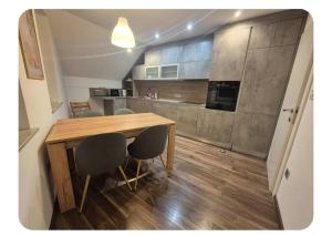 a kitchen with a wooden table and some chairs at Apartma pri lovcu in Trzin