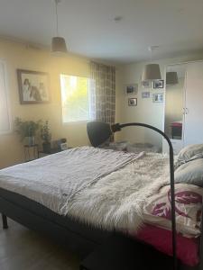 a bedroom with a bed and a chair and a window at Spacious detached house in Mäntsälä