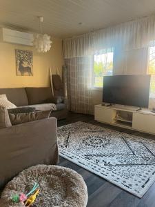 a living room with a couch and a flat screen tv at Spacious detached house in Mäntsälä