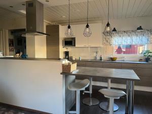 a kitchen with a table and two stools at Spacious detached house in Mäntsälä
