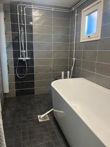 a bathroom with a bath tub and a shower at Spacious detached house in Mäntsälä +5 photos