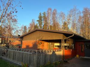 a brick house with a fence in front of it at Spacious detached house in Mäntsälä