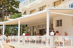 a group of people sitting on the porch of a house at Hotel Panorama in Sveti Vlas