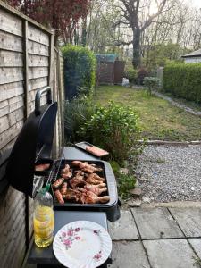 a grill with meat and a plate of food on it at Riverchapel Guesthouse in Courtown