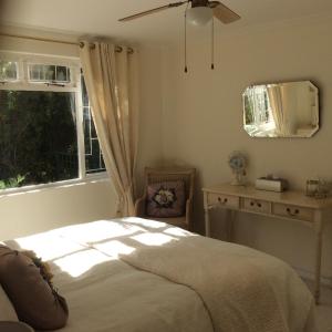 een slaapkamer met een bed en een raam bij On Broadwalk Cottage in Kaapstad