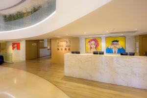 a lobby with a marble counter and paintings on the wall at Inn Hotel Macau in Macau