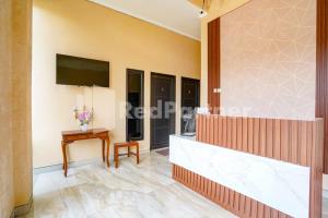 a living room with a television and a table at Griya Poerwoto Syariah near Pasar Klewer Solo RedPartner in Solo