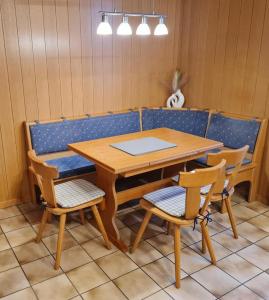 a table and chairs with a table and a bench at Ferienwohnung Sonnenschein in Tülau +3 photos