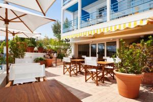 a patio with tables and chairs and a building at Hôtel California in Le Lavandou +24 photos