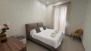 a bedroom with a bed and a table and a window at Le Cupole in Marsala