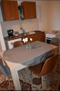 a kitchen with a table with a vase of flowers on it at Elma in Kampor +10 photos