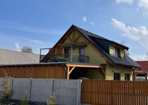 a house with a balcony on top of a fence at Apartmán Blatka in Nová Pec