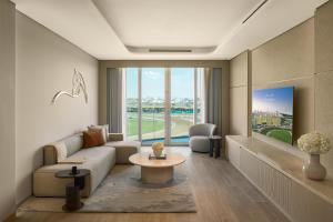 a living room with a couch and a table at The Meydan Hotel Dubai in Dubai