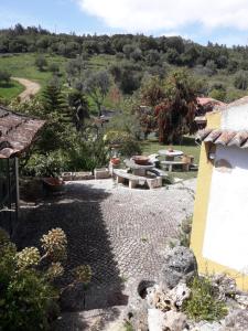 a patio with a table and benches in a yard at Heaven House in Sesimbra
