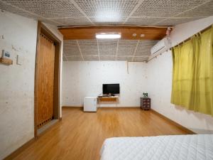 a room with a bed and a television in it at Ddlanchae Guesthouse - New Tower in Jeonju