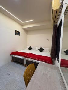 a small room with a bed and two tables at Hotel Shivay Deluxe in Nagpur +33 photos