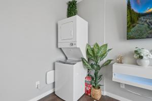 a white refrigerator in a room with a plant at Valclyde Elevated Urban Haven in Minneapolis