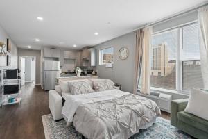 a bedroom with a bed and a couch and a kitchen at Valclyde Elevated Urban Haven in Minneapolis