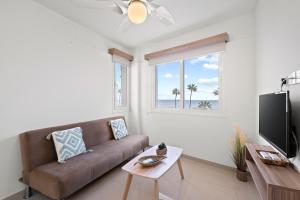 a living room with a couch and a window at Larnaca Bay Suites in Larnaca