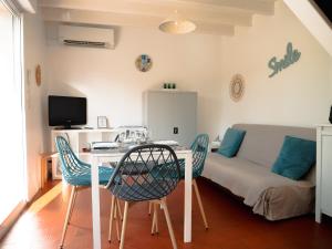 a living room with a table and chairs and a couch at L'ESCAPADE T3 avec terrasse privative in Lussac-les-Châteaux
