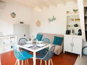 a dining room with a table and blue chairs at L'ESCAPADE T3 avec terrasse privative in Lussac-les-Châteaux