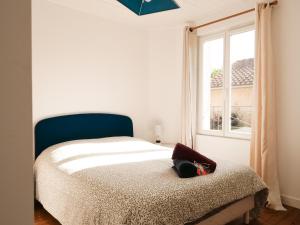 a bedroom with a bed and a window at L'ESCAPADE T3 avec terrasse privative in Lussac-les-Châteaux