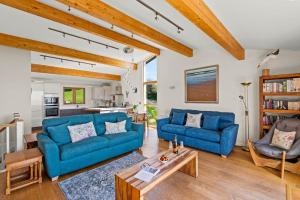 a living room with two blue couches and a table at House 43 in Looe