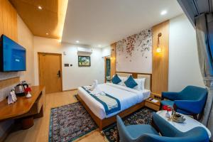 a hotel room with a bed and a desk and chairs at Arkaya Mukteshwar by SuperGlitz Resorts Pvt Ltd in Mukteshwar