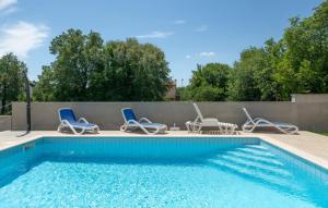 a swimming pool with four chairs and a table and a pool at Villa Paola Vinez in Labin