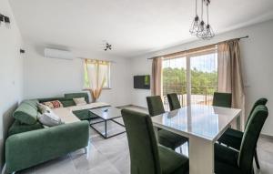 a living room with a table and green chairs at Villa Paola Vinez in Labin