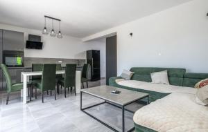 a living room with a green couch and a table at Villa Paola Vinez in Labin
