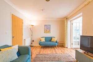 a living room with a blue couch and a television at Gerald's Place in Deal