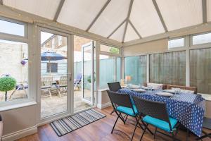 a dining room with a table and chairs and windows at Gerald's Place in Deal