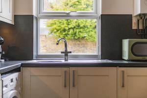 a kitchen with a sink and a window at Gerald's Place in Deal +22 photos