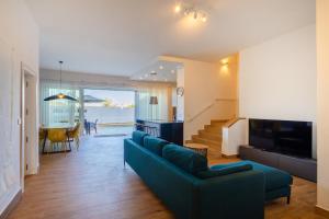 a living room with a blue couch and a television at Dar Sara Holiday Home in Victoria