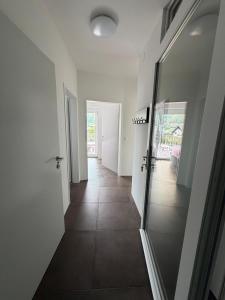 a hallway with white walls and a glass door at Ferienwohnung Sophia in Bad Gleichenberg