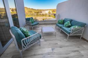 a patio with a couch and chairs on a balcony at Dar Sara Holiday Home in Victoria