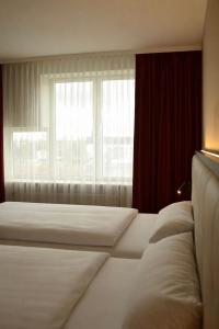 a hotel room with two beds and a window at Hotel Alina in Wiesbaden